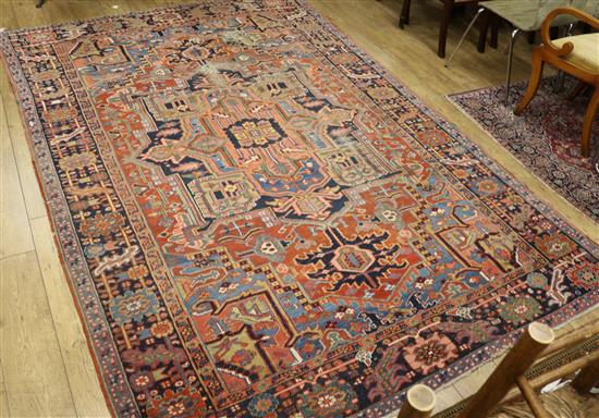 A Heriz brick red ground carpet (holed) 325 x 222cm